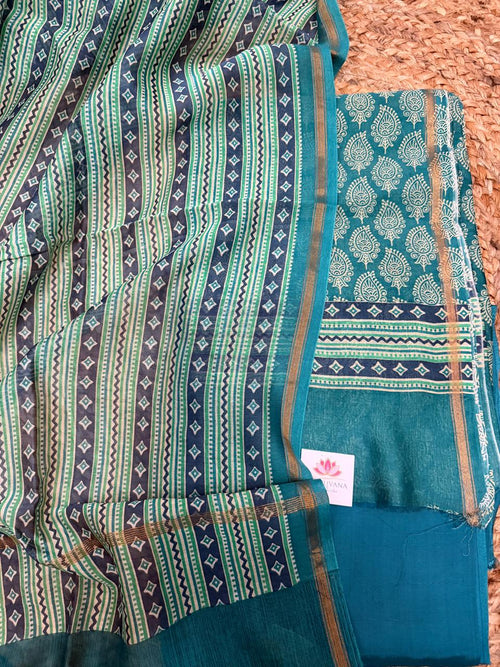 Teal and navy Chanderi silk 3-piece unstitched suit set – angled flat lay on rattan showing navy-green geometric stripe and diamond booti dupatta with gold zari border alongside teal kurta with white paisley booti, navy diamond band, and plain teal Chanderi bottom