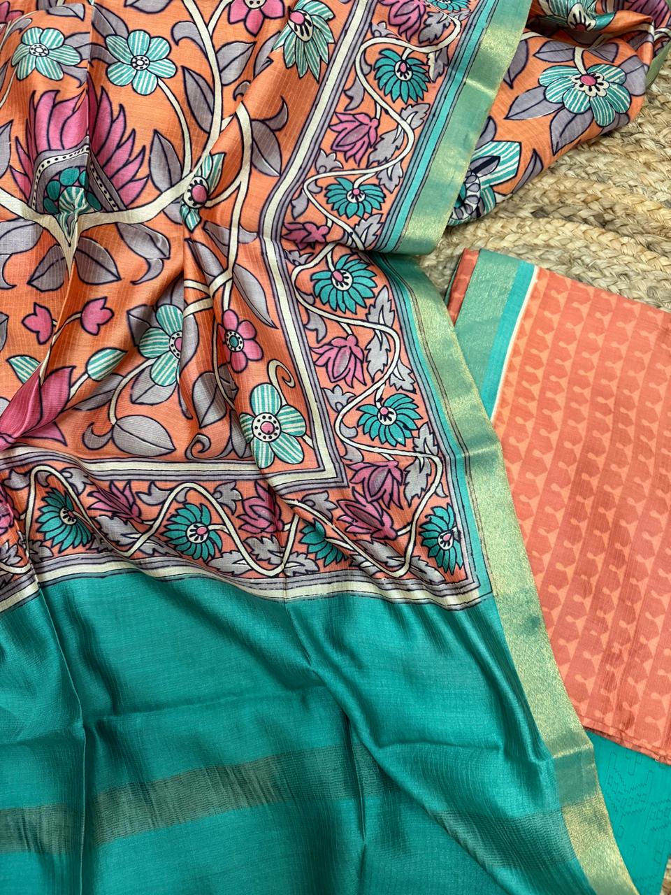 Orange Kalamkari Maheshwari silk dupatta – angled flat lay close-up showing dense teal and pink floral vine Kalamkari print with teal zari border, alongside orange woven kurta fabric and plain teal bottom