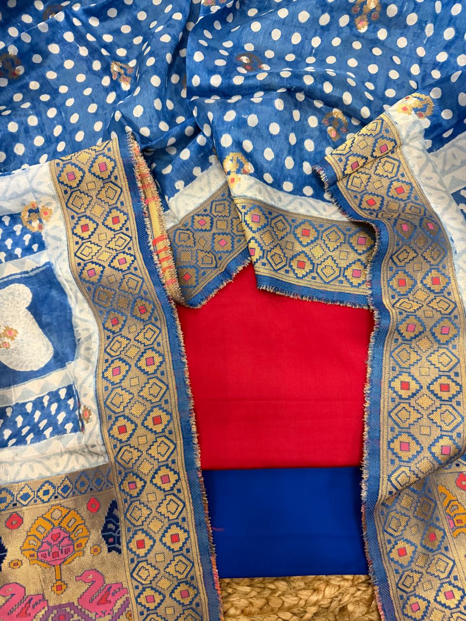 Pink and royal blue 3-piece unstitched suit set – angled flat lay showing fuchsia glaze cotton kurta, royal blue bottom, royal blue polka dot dupatta body with white paisley Bagh print, and gold zari diamond brocade border with Patola pallu detail