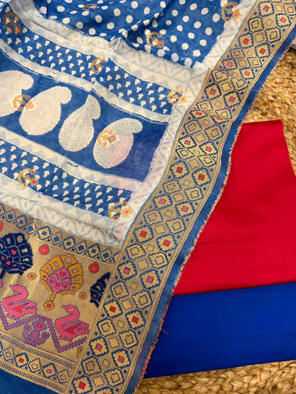 Royal blue Dola silk dupatta – close-up of blue polka dot body with large white paisley Bagh print border, gold zari diamond geometric brocade border, Patola-style swan and tree pallu with fuchsia and yellow motifs, alongside fuchsia kurta and blue bottom fabrics